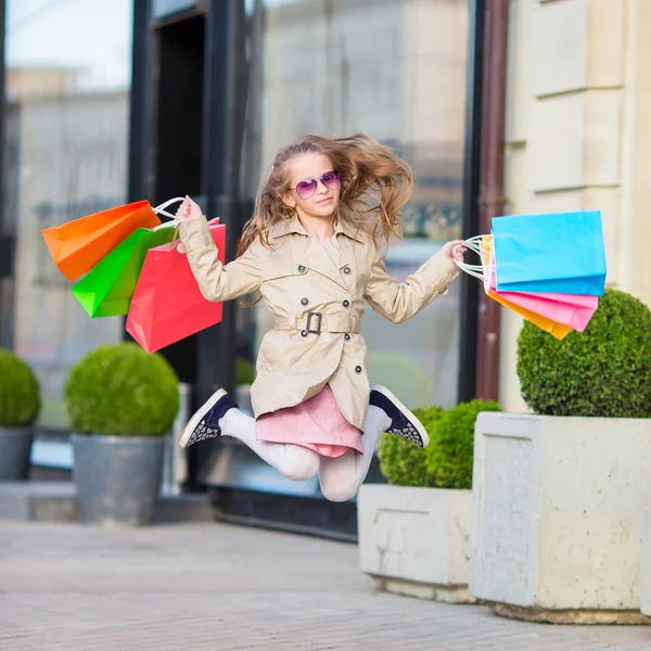 可爱的小女孩走在户外在欧洲购物袋。欧洲城市户外时尚蹒跚学步的孩子 — 图库照片