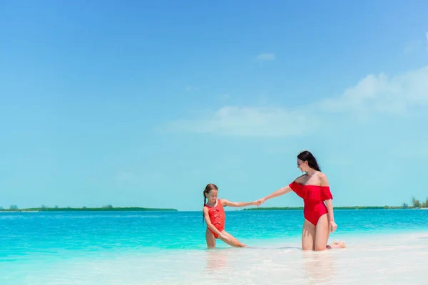 お母さんと子供は浅い水の中の家族。若い母親とビーチでの休暇には小さな娘 — ストック写真