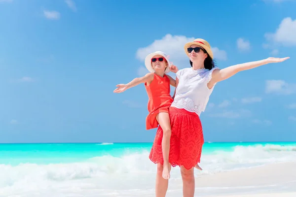 Маленькая очаровательная девочка и молодая мать на тропическом пляже. Семья из двух человек получает много удовольствия во время летних каникул — стоковое фото