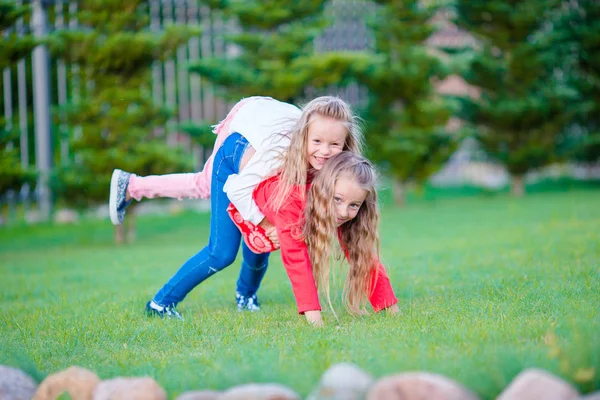 Маленькие счастливые девочки получают много удовольствия на открытом воздухе в парке — стоковое фото