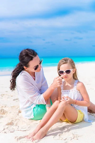 Starostlivá matka použití sluneční krém pro dceru nos na pláži. Koncepce ochrany před ultrafialovým zářením — Stock fotografie