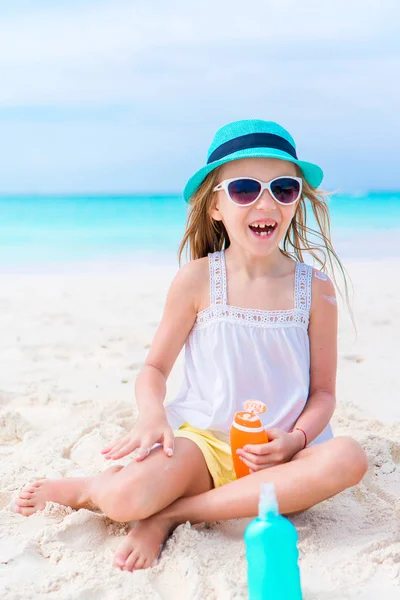 Happy smile girl with suncream bottle on the beach in sunny hot day — Stock Photo, Image