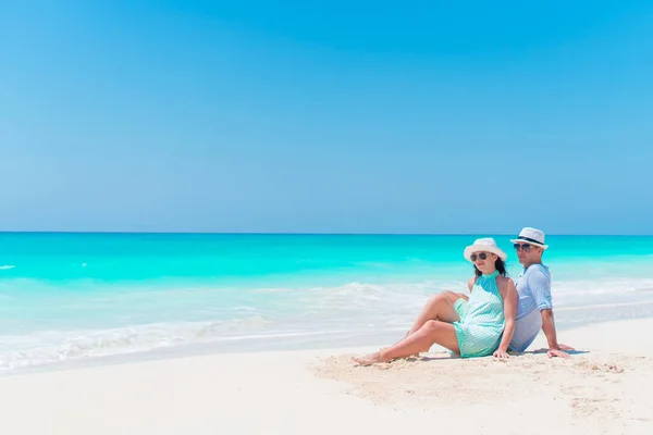 Молодая пара на белом пляже на открытом воздухе. Счастливая семья наслаждается своим медовым месяцем — стоковое фото