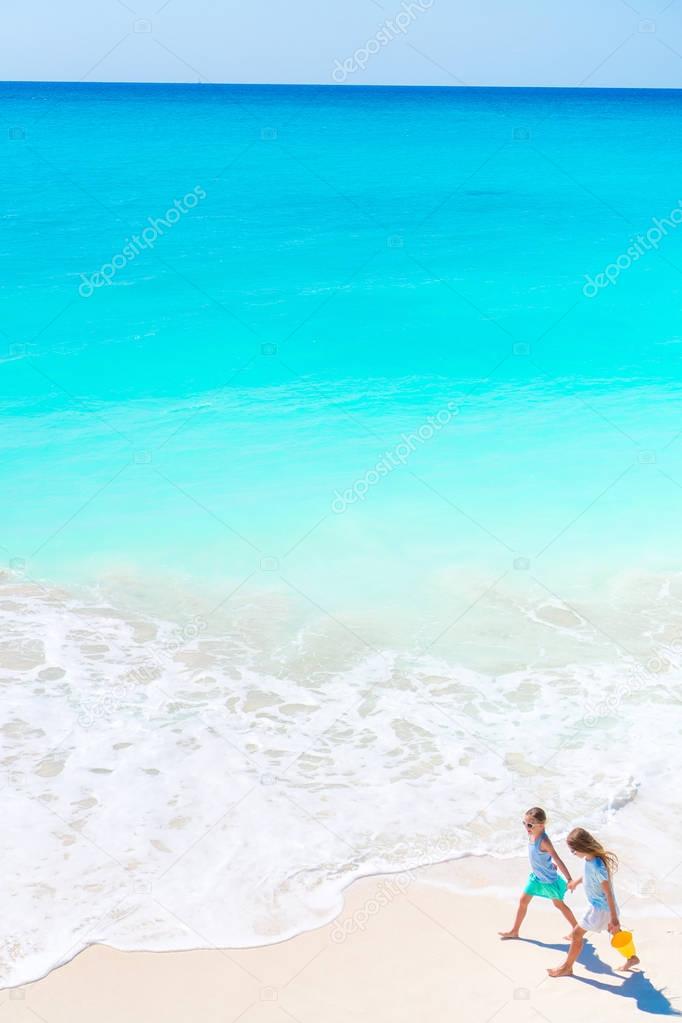 Adorable little girls on the beach. Top view of kids walking on the seashore