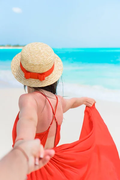 熱帯の海岸に帽子の若い美しい女。赤いドレスの背景海で若い女の子の背面します。私のコンセプトに従ってください。 — ストック写真