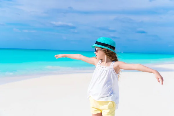 Porträtt av bedårande liten flicka i hatt på vit sandstrand — Stockfoto