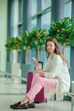 Genç kadın ile smartphone uluslararası havaalanında. Havayolu Yolcu uçuş uçak için bekleyen bir Havaalanı Lounge