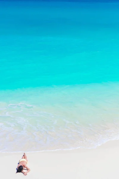 Widok z góry piękny dziewczyna leżąc na plaży w płytkich wodach tropikalnych — Zdjęcie stockowe