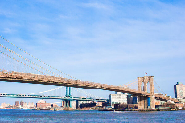 Brooklyn Bridge over river viewed from New York City.