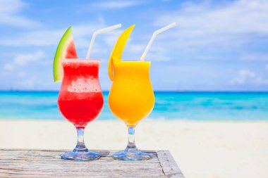Turkuaz deniz arka plan üzerinde taze karpuz ve mango kokteyller