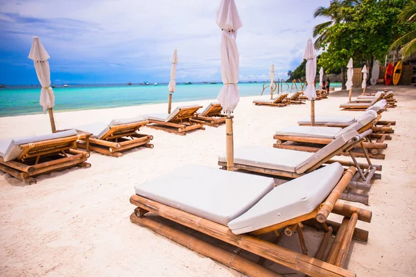 Beach yataklar ve egzotik tropik beyaz kumlu plaj şemsiye — Stok fotoğraf
