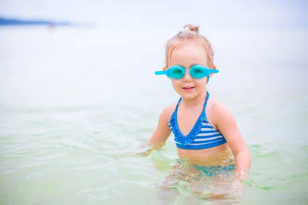 可爱的小女孩在海里游泳的热带海滩度假 — 图库照片