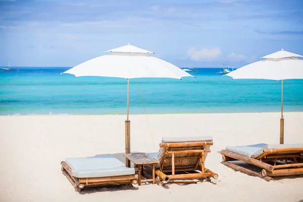 Solstolar och parasoll på exotiska tropiska vit sandstrand — Stockfoto