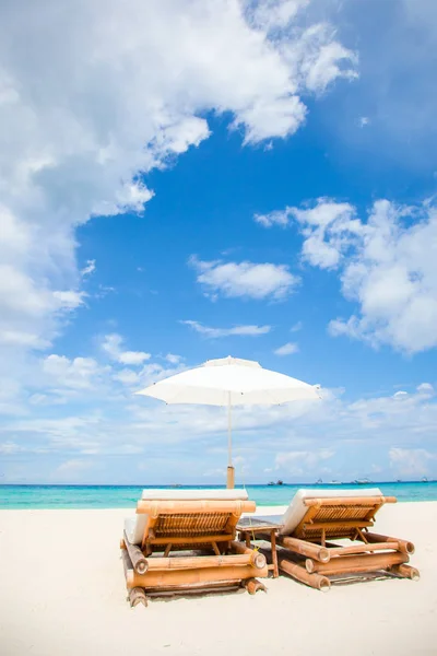 Plážová lehátka a slunečník na exotické tropické pláži — Stock fotografie