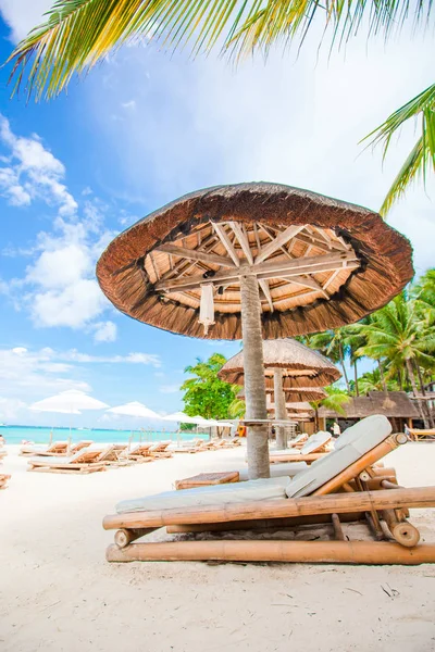 Camas de playa y sombrillas en la exótica playa tropical de arena blanca —  Fotos de Stock