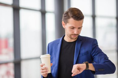 Havaalanında içinde kahve kentsel adamla. Casual genç çocuk giyen takım elbise ceketi. Beyaz adam yatılı için beklerken havaalanında cep telefonu ile