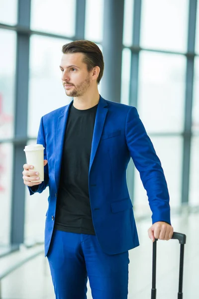 Urban man with coffee inside in airport. Casual young boy wearing suit jacket. Caucasian man with cellphone at the airport while waiting for boarding — Stock Photo, Image
