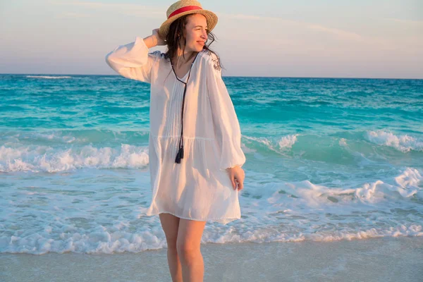 Joven hermosa mujer en la orilla del mar tropical en la puesta del sol. Chica feliz en vestido por la noche en la playa —  Fotos de Stock