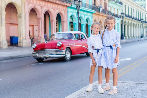 Schattige kleine meisjes in populaire wijk in oud Havana, Cuba. Portret van twee kinderen buiten op een straat van Havana — Stockfoto