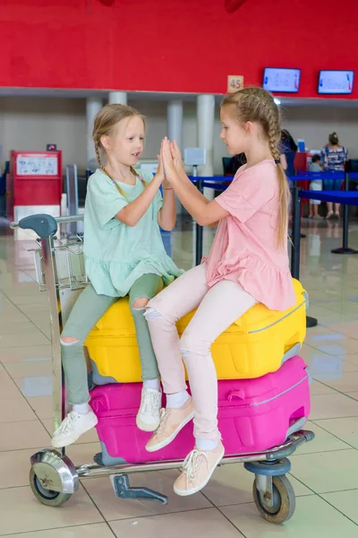 Adorable little girls having fun in airport waiting for boarding — Stock Photo, Image