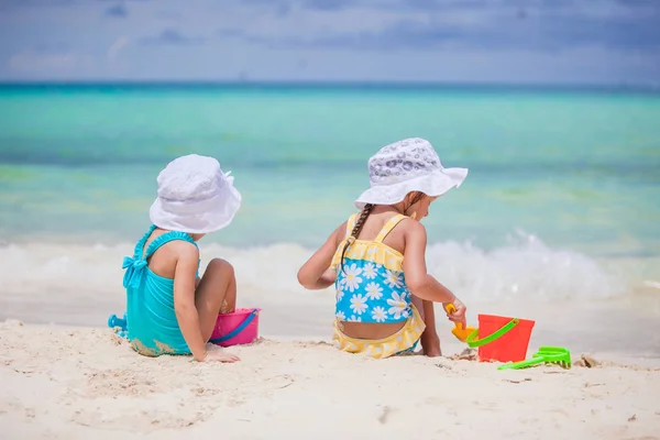 Mutlu küçük kızlar tropikal tatilde plaj oyuncaklarıyla oynuyorlar. — Stok fotoğraf