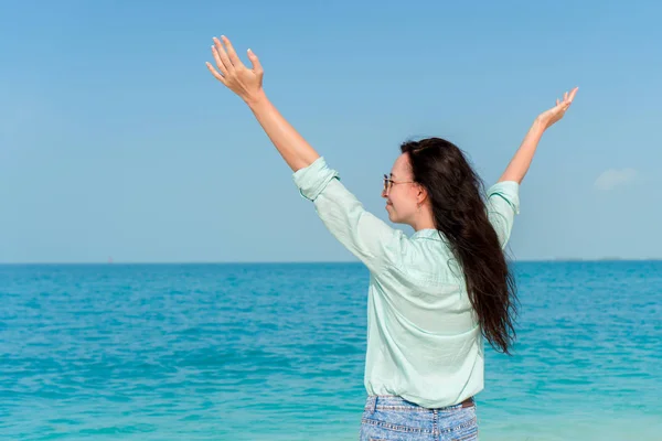 Mooie jongedame aan tropische kust. Achteraanzicht van jong meisje achtergrond de zee — Stockfoto