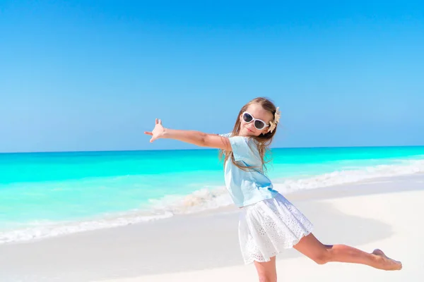 Splendida bambina in spiaggia che si diverte molto in vacanza estiva. Adorabile bambino che salta sulla riva del mare — Foto Stock