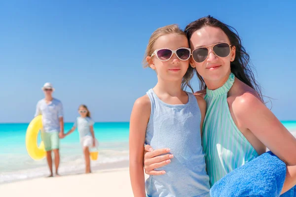 快乐美丽四口之家在一个热带的海滩上。肖像的母亲与父亲和妹妹的小女孩背景。 — 图库照片