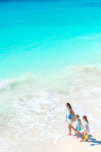 Adorable little girls and young mother on white beach. View to the family on the beach and ocean from above — Stock Photo, Image