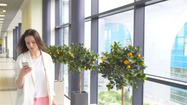 Genç kadın ile smartphone uluslararası havaalanında. Havayolu Yolcu uçuş uçak için bekleyen bir Havaalanı Lounge