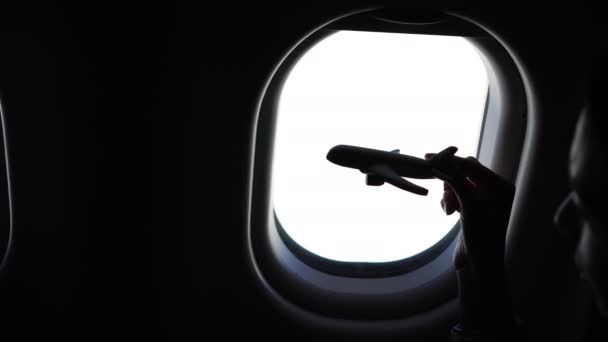 Primer plano de la mano sosteniendo un avión modelo juguete fondo ventana en los aviones — Vídeos de Stock