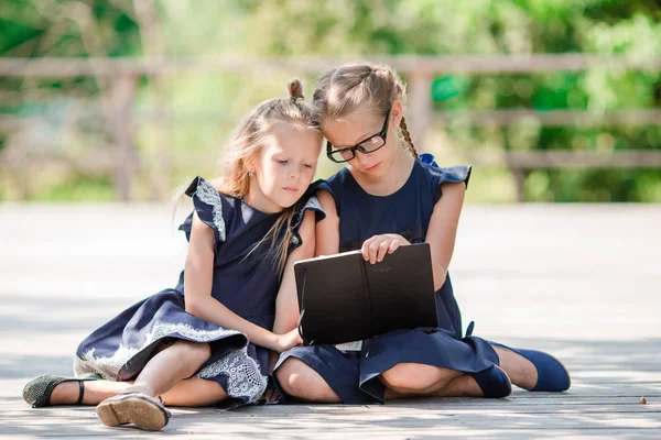 Adorables niñas de la escuela con notas y lápices al aire libre. Regreso a la escuela . —  Fotos de Stock