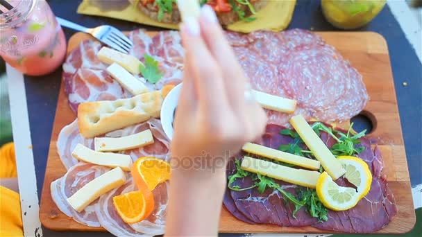 Finom olasz ételeket. Friss bruschettes, a sajt és a hús a táblán a szabadtéri kávézóban csodálatos kilátás olaszországi Manarola — Stock videók