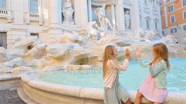 Schattige meisjes in de buurt van de Trevifontein in Rome. Gelukkige kinderen genieten van hun Europese vakantie in Italië — Stockvideo