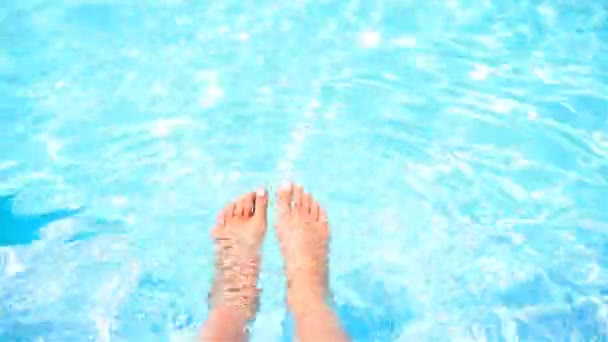 Vrouwelijke voeten ontspannen bij het zwembad. Slow Motion — Stockvideo