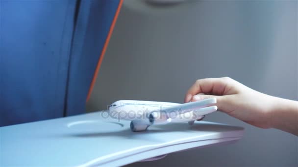 Primer plano de la mano sosteniendo un avión modelo juguete fondo ventana en el interior de la aeronave — Vídeos de Stock