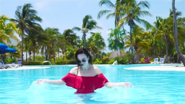 Красивая молодая женщина отдыхает в бассейне. Счастливая девушка в открытом бассейне в роскошном отеле — стоковое видео