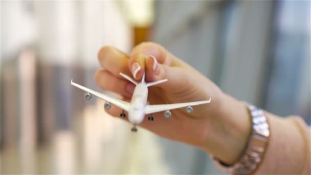 Female hand holding toy airplane, copy space for text. Passenger with small model airplane at the airport. SLOW MOTION — Stock Video