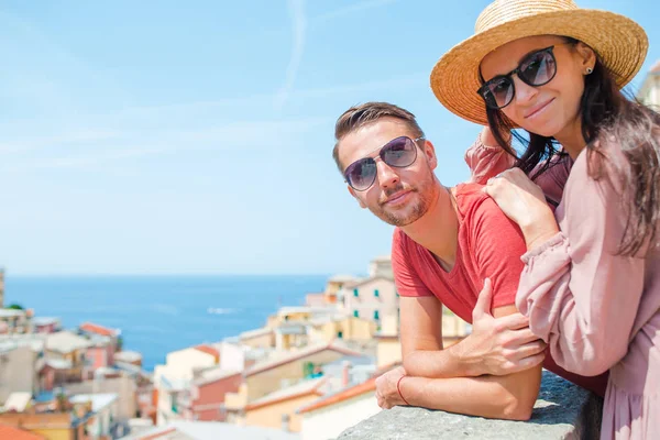 Joven familia de dos con gran vista en el antiguo pueblo de Riomaggiore en luna de miel, Cinque Terre, Liguria, Italia. Vacaciones italianas europeas . —  Fotos de Stock