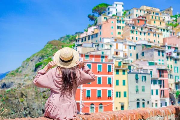 Jonge vrouw met prachtig uitzicht op de oude Italiaanse dorp Riomaggiore, Cinque Terre, Ligurië, Italië. Europese Italiaanse vakantie. — Stockfoto