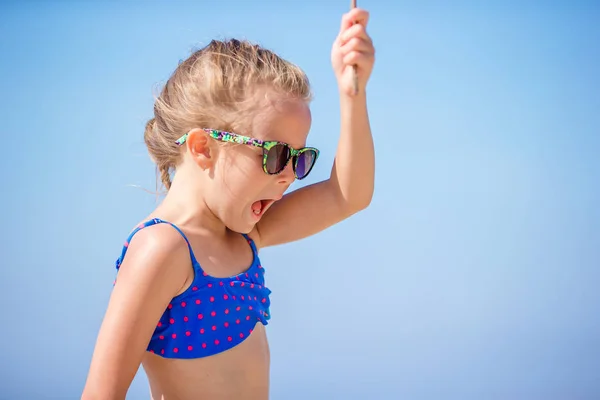 Rozkošná holčička bavit se na tropické pláži na dovolené vřít — Stock fotografie