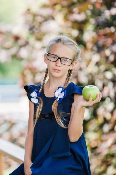 Adorable niña de escuela con manzana verde al aire libre. Regreso al concepto escolar —  Fotos de Stock