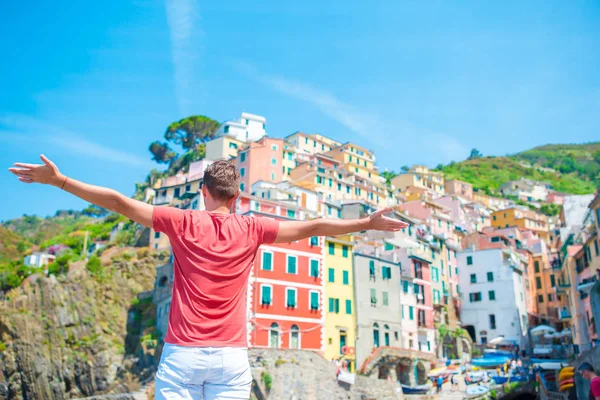 Młody człowiek z pięknym widokiem na Stare włoskie miejscowości Riomaggiore, Cinque Terre, Liguria, Włochy. Włoskie wakacje Europejskiej. — Zdjęcie stockowe