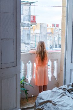 Eski Havana, Küba'da sokakta seyir dairede eski balkonda küçük kız.
