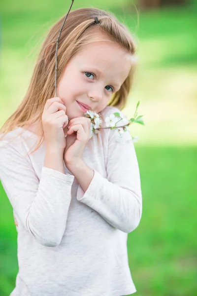 可爱的小女孩，在绽放春日的苹果园树的画像 — 图库照片