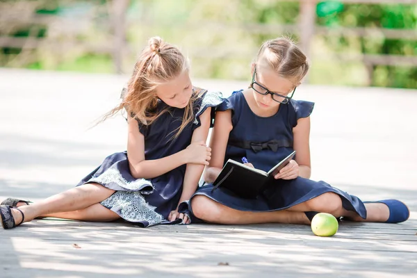 Adorables petites écolières avec des notes et des crayons en plein air. Retour à l'école . — Photo