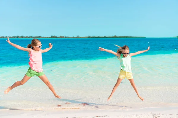 Adorabili bambine che si divertono sulla spiaggia piena di stelle marine sulla sabbia — Foto Stock