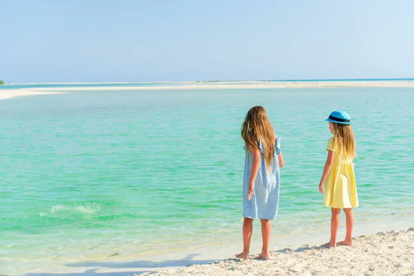 Маленькие девочки веселятся на тропическом пляже, играя вместе на берегу моря — стоковое фото