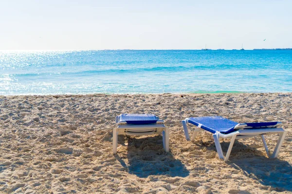 Camas de sol de praia na areia branca em luz suave da noite — Fotografia de Stock