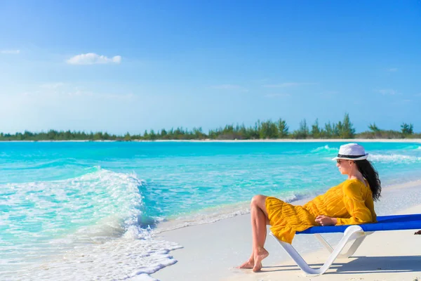 Jovem mulher de chapéu em uma praia tropical relaxante no leito solar — Fotografia de Stock